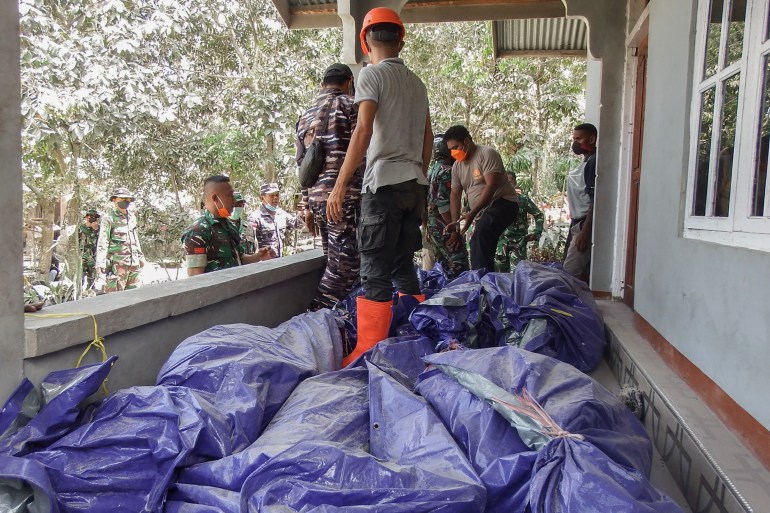 d8a8d98ad8b3-3-1730699773 Members of a rescue team carry away body bags containing deceased people at Klatanlo village, in East Flores Regency, East Nusa Tenggara, on November 4, 2024, after Mount Lewotobi Laki-Laki erupted overnight. - At least six people died after a volcano in eastern Indonesia erupted several times overnight, officials said on November 4, raising the alert level to the highest of a four-tiered system. (Photo by ARNOLD WELIANTO / AFP)