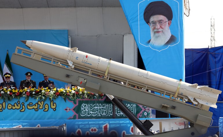 epa11616785 A truck carrying a medium range missile passes by a picture of Iranian Supreme Leader Ayatollah Ali Khamenei during the annual military parade marking the Iraqi invasion in 1980, which led to an eight-year-long war (1980-1988); in Tehran, Iran, 21 September 2024. According to IRNA newes agency, Iranian president Masoud Pezeshkian said 'our defense system power is on that level that no enemy even dares to think to attack against Iran, and we will continue to develop our defense system in any aspects.' EPA-EFE/ABEDIN TAHERKENAREH