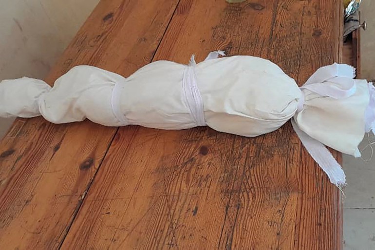 SENSITIVE MATERIAL. THIS IMAGE MAY OFFEND OR DISTURB A baby's body lies wrapped in white material after it died at an orphange in Khartoum, Sudan, in this handout image released May 27, 2023. To match special report SUDAN-POLITICS/ORPHANAGE Courtesy of Heba Abdullah/Handout via REUTERS THIS IMAGE HAS BEEN SUPPLIED BY A THIRD PARTY. MANDATORY CREDIT.