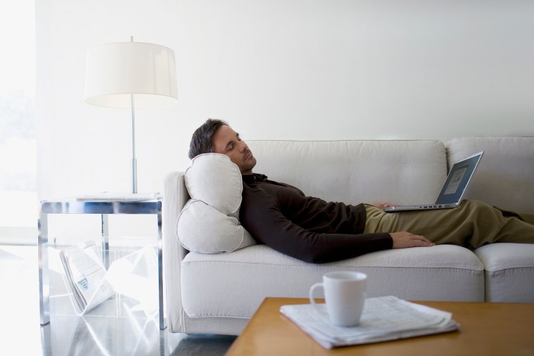 gettyimages-88621059-1731435906 Man with laptop sleeping on sofa - stock photo
