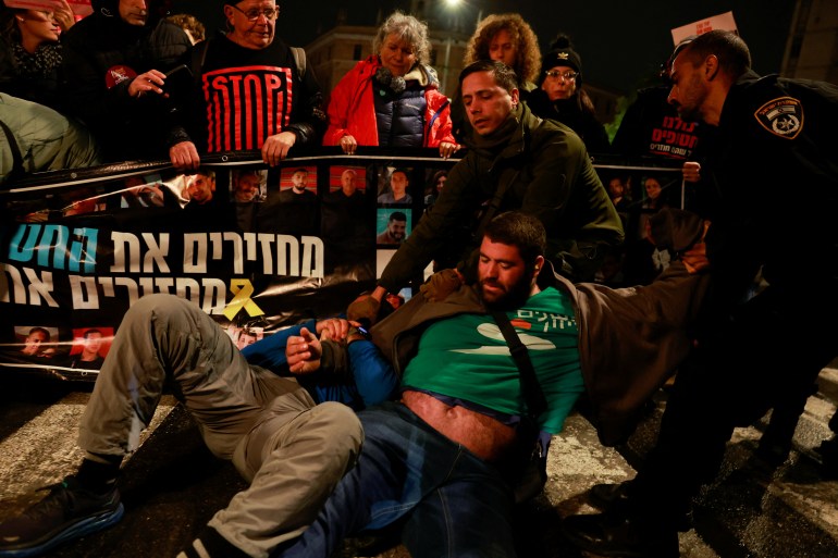 Police officers drag demonstrators as people block a road during a protest in support of the hostages kidnapped during the deadly October 7, 2023 attack by Hamas, marking a year since a group of Israeli hostages were released from Gazan captivity, in Jerusalem, November 27, 2024. REUTERS/Ammar Awad TPX IMAGES OF THE DAY
