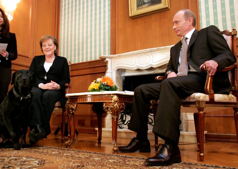 German Chancellor Angela Merkel (L) and Russian President Vladimir Putin look at his dog Conny before their talks at the presidential residence near the Black Sea resort of Sochi, January 21, 2007. Merkel arrived in Russia on Sunday for talks with Putin on European energy concerns and a standoff over meat imports that has pitted Moscow against the EU. REUTERS/Fabrizio Bensch (RUSSIA)