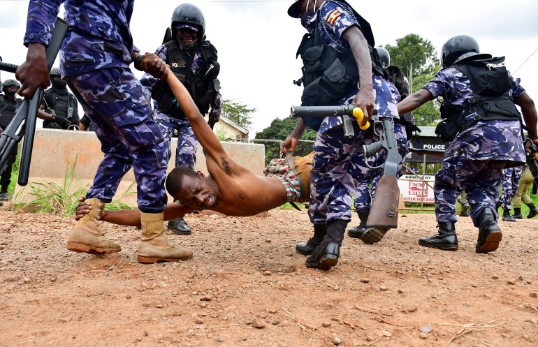 rtx8ad7h Ugandan riot policemen detain a supporter of presidential candidate Robert Kyagulanyi, in Luuka district
