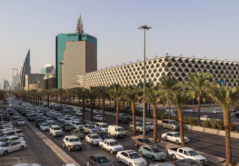 shutterstock_448390411-1714833658 RIYADH, SAUDI ARABIA - OCTOBER 15, 2015. Traffic jam on King Fahd road in Riyadh full of white cars and taxi near Riyadh National Library with Al Faisaliah tower and Kigdom tower in back