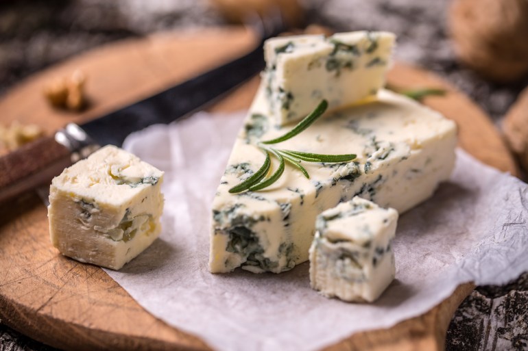 gettyimages-504446366-1733413426 Slice of French Roquefort cheese with walnuts
