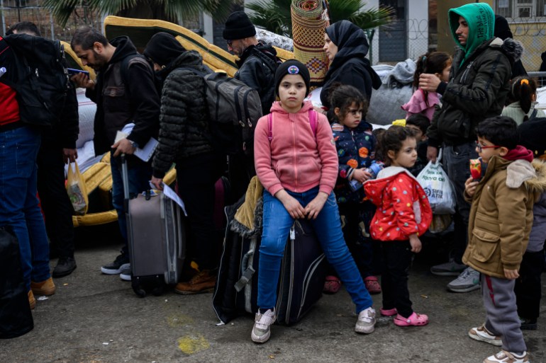 Syrian refugee Leyla Hidir, 12 years old, waits in a queue with her belongings to enter Syria to return to Idlib from Turkey, at the Cilvegozu border crossing gate in Reyhanli district in Hatay on December 12, 2024. - Islamist-led rebels declared on December 8, 2024, that they have taken the Syrian capital in a lightning offensive, sending President Bashar al-Assad fleeing and ending five decades of Baath rule in Syria. (Photo by Yasin AKGUL / AFP)