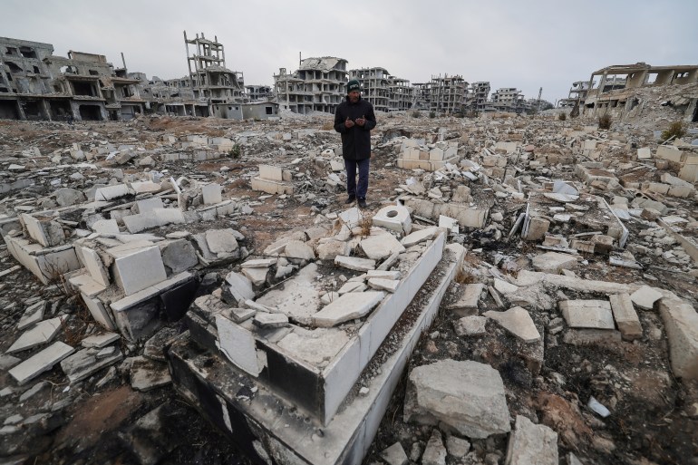 49-4-1736158953 Ibrahim Daraji, who said he is still mourning two sons, one disappeared into Sednaya prison and another lost to a mortar strike in Al-Yarmouk camp, prays at damaged Martyrs cemetery where his son is buried at al-Yarmouk Palestinian refugee camp, after fighters of the ruling Syrian body ousted Bashar al-Assad, in Damascus, Syria December 22, 2024. REUTERS/Zohra Bensemra