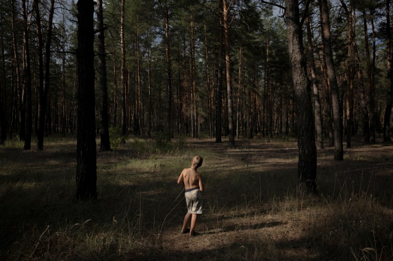 d8a8d98ad9824-3-1740474290 Oleksandr Fomenko, 8, stands in one of the few sections of his native forest that hasn't been mined and is accessible for mushroom picking, near Yarova, Sviati Hory national park, Donetsk region, amid Russia's attack on Ukraine, July 28, 2024. About 425,000 hectares of forest across the country have been found to be contaminated by mines and unexploded ordnance, an area half the size of Cyprus, according to the environment ministry. The damage to forests is part of a broader trail of environmental destruction caused by the war, which could leave a bleak natural legacy for decades to come, having poisoned earth and rivers, polluted the air and left vast tracts of the country riddled with mines, according to the experts. "I lived here all my life. My parents lived here, my grandmother lived here," Oleksandr's grandmother Zhenia, 49, said. "I always knew where the mushrooms would grow. But now, I don't. We can only go to places that have been demined." REUTERS/Thomas Peter SEARCH "PETER UKRAINE FORESTS" FOR THIS STORY. SEARCH "WIDER IMAGE" FOR ALL STORIES.
