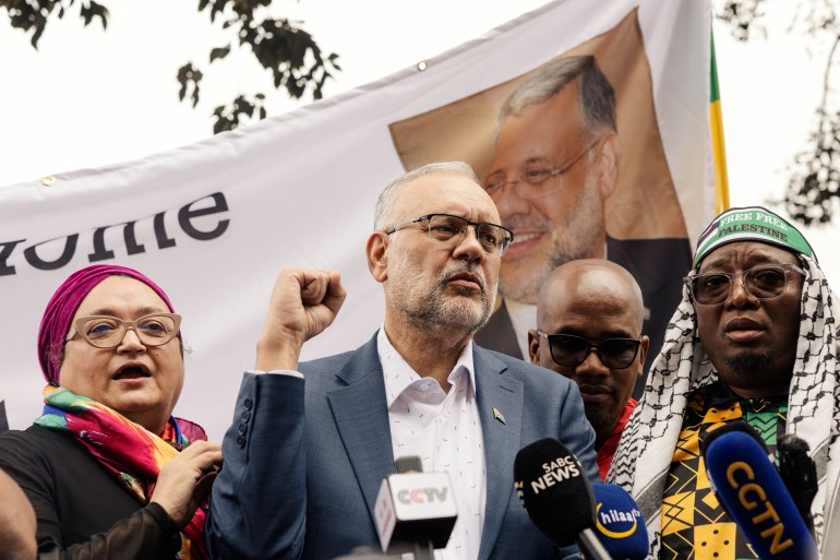 6532-1742761373-2 Former South African Ambassador to the United States Ebrahim Rasool (c), addresses supporters upon his arrival at the Cape Town International airport, in Cape Town, on March 23, 2025. Ties between Washington and Pretoria have slumped since Trump cut financial aid to South Africa over its land policy, genocide case against US ally Israel and other foreign policy clashes. US Secretary of State Marco Rubio said last week Rasool was expelled after he described Trump's Make America Great Again movement as a supremacist reaction to diversity in the US. (Photo by GIANLUIGI GUERCIA / AFP)