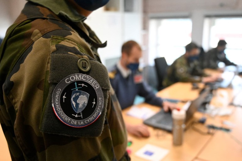 7-1743076726 The badge showing the logo of the COMCYBER commandement de la cyberdefense is seen on the arm of a French soldier attending the cyber defense exercise DEFNET 2021 on March 18, 2021 in Rennes, western France. / AFP / Damien MEYER