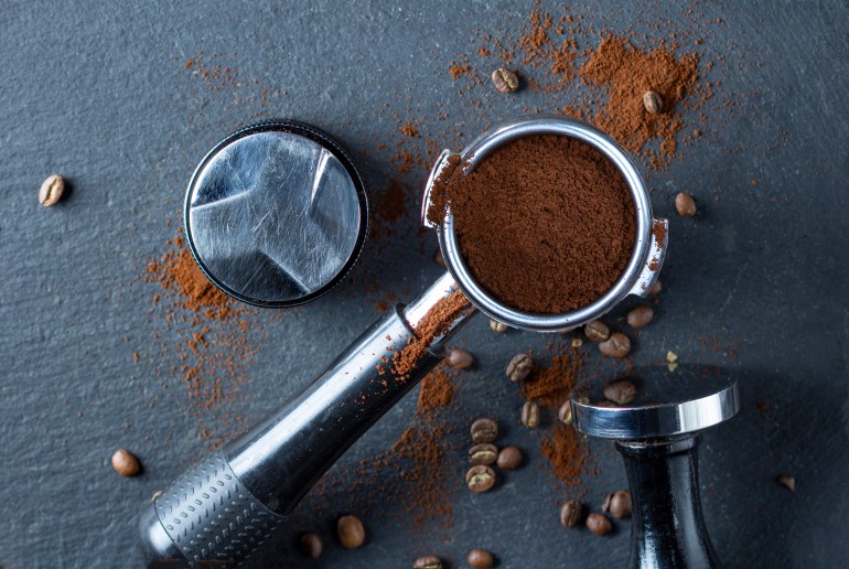 Portafilter with coffee and temper on table