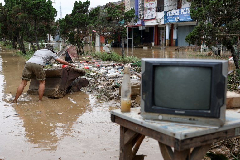 d8a8d98a-2-1741412741 A man saves his goods as floods hit the residential area following heavy rains in Bekasi, on the outskirts of Jakarta, Indonesia, March 4, 2025. REUTERS/Ajeng Dinar Ulfiana