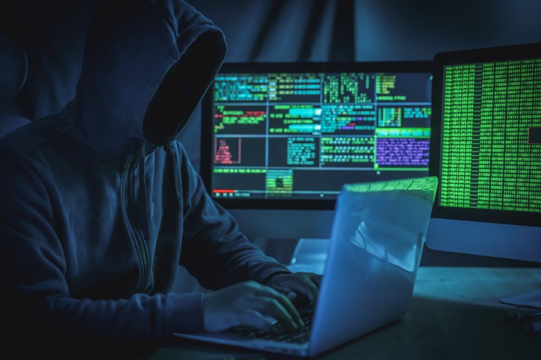 Wanted hackers coding virus ransomware using laptops and computers.