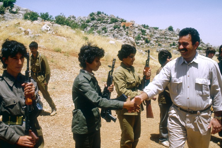 gettyimages-542275338-1735830726 PKK's General Secretary and military leader Abdullah Ocalan greets women soldiers at the Mahsun Korkmaz Academy military training camp. | Location: Lebanon. (Photo by Maher Attar/Sygma via Getty Images)