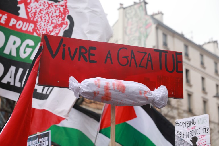 paris2-1742729214 PARIS, FRANCE - MARCH 22: A protest sign reading 'Vivre a Gaza tue' (Living in Gaza kills) is seen during a demonstration marking the International Day for the Elimination of Racial Discrimination in Paris, France, on March 22, 2025. Thousands gathered in solidarity with Palestinians and to protest racial discrimination and injustice worldwide. (Photo by Mohamad Salaheldin Abdelg Alsayed/Anadolu via Getty Images)