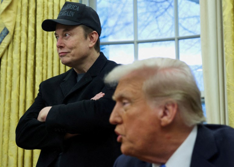 trump-musk9-1739730753 Elon Musk listens to U.S. President Donald Trump speak in the Oval Office of the White House in Washington, D.C., U.S., February 11, 2025. REUTERS/Kevin Lamarque