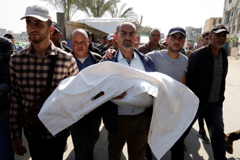 2aza-1745579982 A man carries the body of a Palestinian child killed in Israeli strikes, at Nasser hospital, in Khan Younis, in the southern Gaza Strip, April 19, 2025. REUTERS/Hatem Khaled