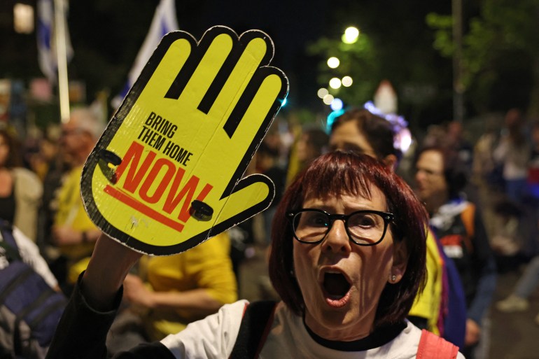 afp_6801d984adfe-1744951684 A woman chants slogans as relatives and supporters of Israeli hostages, held captive in the Gaza Strip since the October 2023 attacks by Palestinian militants, hold placards and chant slogans during an anti-government demonstration calling for action to secure their release, outside the Israeli prime minister's residence in Jerusalem on April 17, 2025. (Photo by AHMAD GHARABLI / AFP)