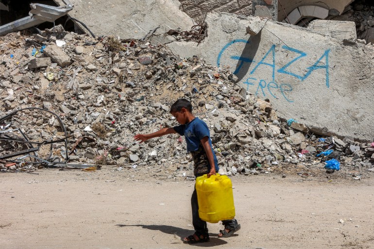 afp_68077d170826-1745321239 A boy walks carrying a jerrycan filled with water past the rubble of a destroyed building in Gaza City on April 21, 2025.