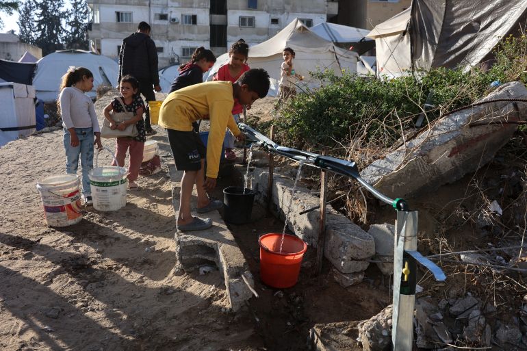 afp_680e005e7813-1745748062 Palestinian children fill containers with water in Gaza City, in the central Gaza Strip on April 26, 2025.