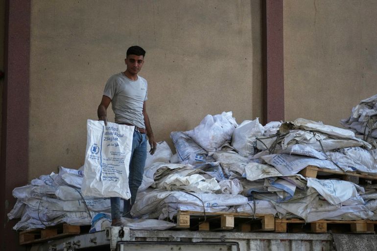 ap_680e043aca3bb-1745749050 A Palestinian worker holds one of the empty sacks of flour at the World Food Program warehouse in the Nuseirat refugee camp, Gaza Strip, Saturday April 26, 2025. (AP Photo/Abdel Kareem Hana)