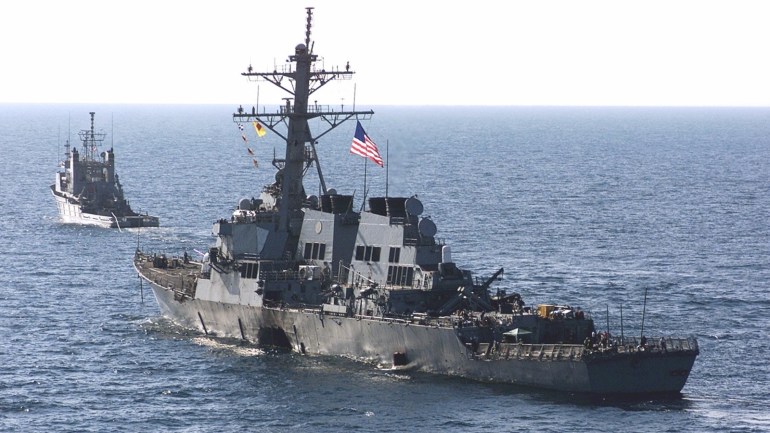 e2b3f81e-8163-4b75-ad75-d0239adf77a7 380991 01: The U.S. Navy destroyer USS Cole is towed away October 29, 2000 from the port city of Aden, Yemen, into open sea by the Military Sealift Command ocean-going tug USNS Catawba. Sailors lined the deck of the Cole, saluting a giant U.S. flag to the national anthem as the destroyer damaged in an apparent suicide bombing was towed out of Aden's port and headed home. (Sgt. Don L. Maes/U.S. Marine Corps via Newsmakers)