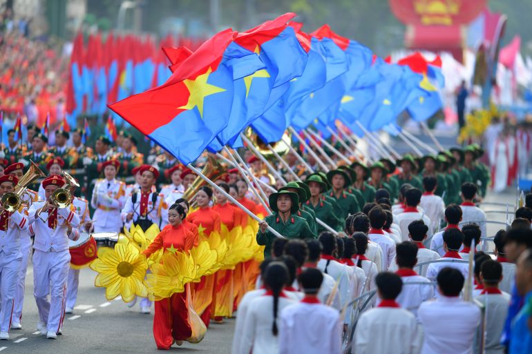 epa_6811aeefb211-1745989359 epa12064000 People holding flags march during a parade marking the 50th anniversary of the Liberation of the South and National Reunification Day, in Ho Chi Minh City, Vietnam, 30 April 2025. Vietnamese Reunification Day is observed annually on 30 April. EPA-EFE/STRINGER