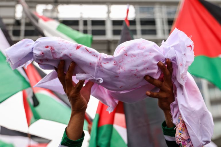 getty_680e033786-1745748791 KUALA LUMPUR, MALAYSIA - MARCH 02: A protester holds a cloth imitating a dead baby during a rally on March 02, 2024, in Kuala Lumpur, Malaysia. In solidarity with Palestine amidst reports of over 100 killed and about 750 wounded, a mega rally organized by the Palestine Solidarity Secretariat marched from the Tabung Haji building, passing the United States Embassy, Kuala Lumpur City Centre (KLCC), to Independence (Merdeka) Square before concluding at Padang Merbok, as Israeli forces fired at Palestinians while collecting food aid in the southwest of Gaza City, highlighting the besieged enclave's unprecedented hunger crisis. (Photo by Annice Lyn/Getty Images)