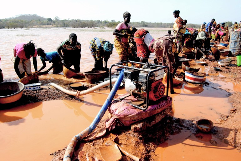 gettyimages-1296669724-1732654015 Malian women working at an artisanal gold mining site in Sadiola (northwestern Mali). Gold attracts many young people from the region (Ghana, Guinea, Burkina-Faso, Senegal..) to its mining sites where gold panners use rudimentary means for its exploitation. (Photo by: Amadou Keita/Afrikimages Agency/Universal Images Group via Getty Images)