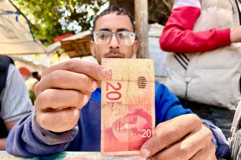 المواطن عبده أبو علوان يعمل على إصلاح الأوراق النقدية اصلاح العملات النقدية التالفة في غزة
