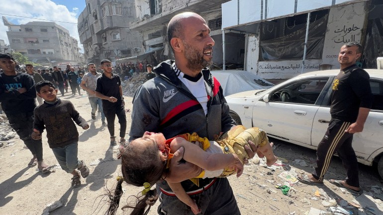 reuters_67f7dbf6-1744296950 A Palestinian man reacts as he holds an injured child at the site of an Israeli strike on a house in Shejaia, in Gaza City, April 10, 2025. REUTERS/Stringer