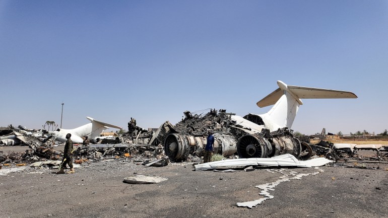 reuters_67fd5c63-1744657507 Members of Sudanese army walk next to destroyed planes' wreckages on the tarmac at Khartoum Airport, after the Sudanese army deepened its control over the capital Khartoum, from the Rapid Support Forces (RSF), in Khartoum, Sudan March 27, 2025. REUTERS/El Tayeb Siddig