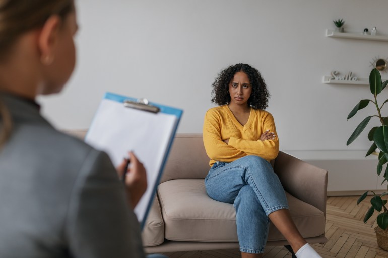 Counselor speaking to unhappy black woman at office during psychotherapy session, giving advice to young female customer. Psychologist having consultation with depressed African American client