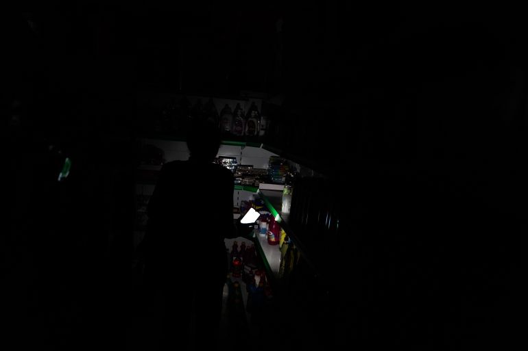 spain1-1745869159 LISBON, PORTUGAL - APRIL 28: People shop for groceries in a dark shop, using their phone as flashlight during a widespread power outage that struck Spain and Portugal around midday on Monday, with the cause still unknown in Lisbon, Portugal on April 28, 2025. ( Stringer - Anadolu Agency )