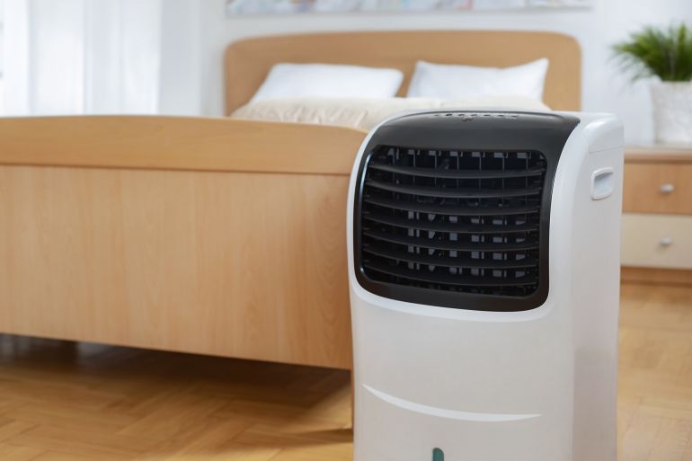 56t-1747321668 Portable mobile air conditioner stands in the bedroom at home, copy space