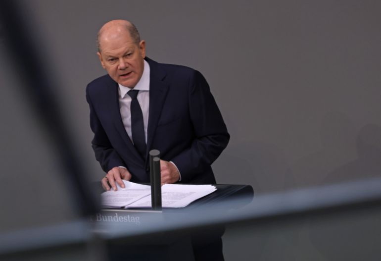 7ac0d6e41-1742555266 BERLIN, GERMANY - MARCH 02: German Chancellor Olaf Scholz speaks in the Bundestag one year on since his "Zeitenwende" speech, the term he used following Russia's military invasion of Ukraine to describe a new era in the European political landscape, on March 02, 2023 in Berlin, Germany. Scholz said today that Germany stands resolutely behind Ukraine and that Putin has miscalculated if he thinks time is on his side in Russia's ongoing war. A crucial part of Scholz's speech one year ago was the announcement of a special EUR 100 billion fund to modernize Germany's under-funded military, though critics charge too little of the fund has so far been spent. Overall Scholz has again and again been perceived as failing to show determined leadership when it comes to Germany's military and its military support for Ukraine. (Photo by Sean Gallup/Getty Images)