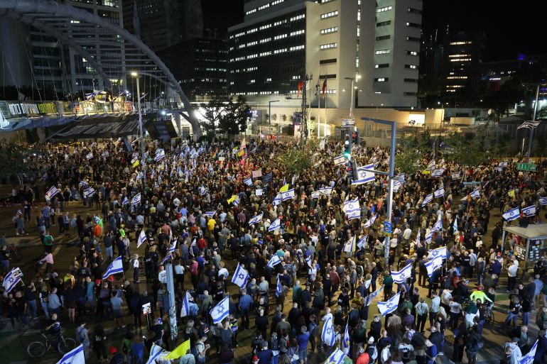 Demonstrators raise placards and Israeli flags during an anti-government protest calling for action to secure the release of Israeli hostages held captive since the October 7 attacks by Palestinian militants in the Gaza Strip and to end the war, in front of the Israeli Defence Ministry in the coastal city of Tel Aviv on May 3, 2025. (Photo by Jack GUEZ / AFP)