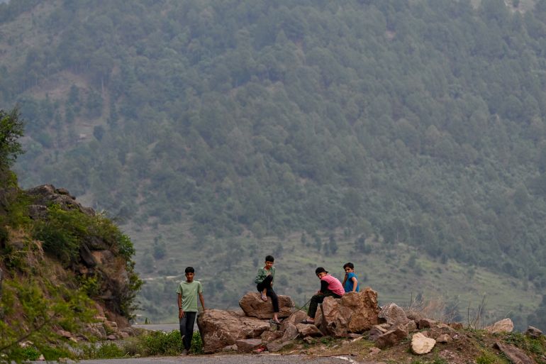afp_6818bf7edd3a-1746452350 Children sit along the main road leading towards Chak Banola village near Mendhar town in Jammu on May 5, 2025. (Photo by Punit PARANJPE / AFP)