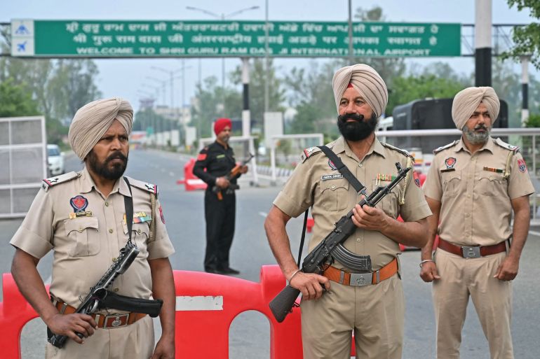 afp_681b03ea1530-1746600938 Policemen stand guard on the entrance road of the Shri Guru Ram Das Ji International Airport on the outskirts of Amritsar on May 7, 2025.