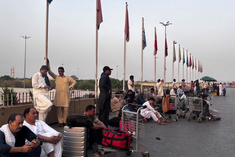 afp_681b05b34b49-1746601395 Passengers wait outside at Jinnah International airport after all domestic and international flights were cancelled in Karachi on May 7, 2025.