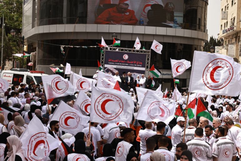 afp_6821de2864e9-1747050024 Palestinian Red Crescent crews hold a rally on World Red Cross and Red Crescent Day in Ramallah city in the occupied West Bank on May 12, 2025, to call for the protection of medical personnel and humanitarian workers in Gaza. (Photo by Zain JAAFAR / AFP)