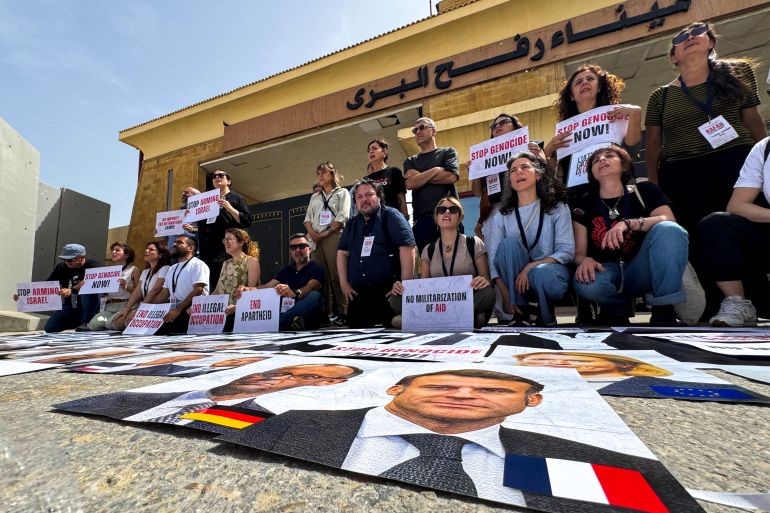 Italian and European parliament members hold placards during a protest in front of the Egyptian side of the Rafah border crossing, calling for an end to the war and for aid to be allowed into the Gaza Strip, on May 18, 2025.