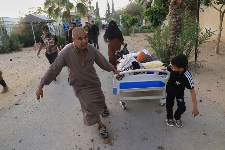 Palestinians evacuate patients from the European hospital in Khan Younis, Gaza, after it was hit by an Israeli army airstrike, Tuesday, May 13, 2025. The Israeli military said it had carried out a strike targeting what it said was a Hamas "command and control center" located beneath the hospital. (AP Photo/Mariam Dagga)