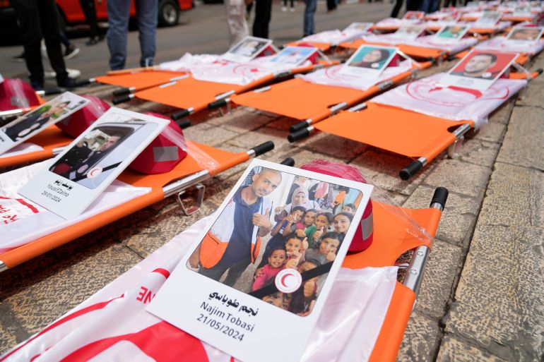 ap_6821de80754b0-1747050112 Posters with names and pictures of fallen paramedics during a symbolic funeral for 48 Palestinian Red Crescent Society members who lost their lives in the line of humanitarian duty during the Israel Hamas war in Gaza, according to a PRCS statement, marking the World Day of Red Cross and Red Crescent, in the West Bank city of Ramallah Monday, May 12, 2025. (AP Photo/Nasser Nasser)
