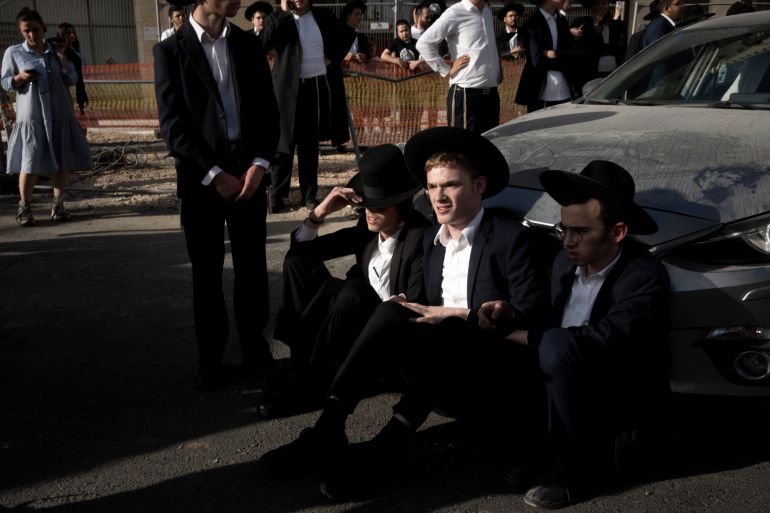 ap_6823496ba0afe-1747143019 Ultra-Orthodox Jewish men block a car from crossing Jaffa Street in central Jerusalem, Thursday, Sept. 29, 2022 to protest attempts to force them to register for Israel's military draft. Military service is mandatory for most Jewish Israeli men, but the ultra-Orthodox often receive exemptions in order to continue their religious studies. (AP Photo/ Maya Alleruzzo)