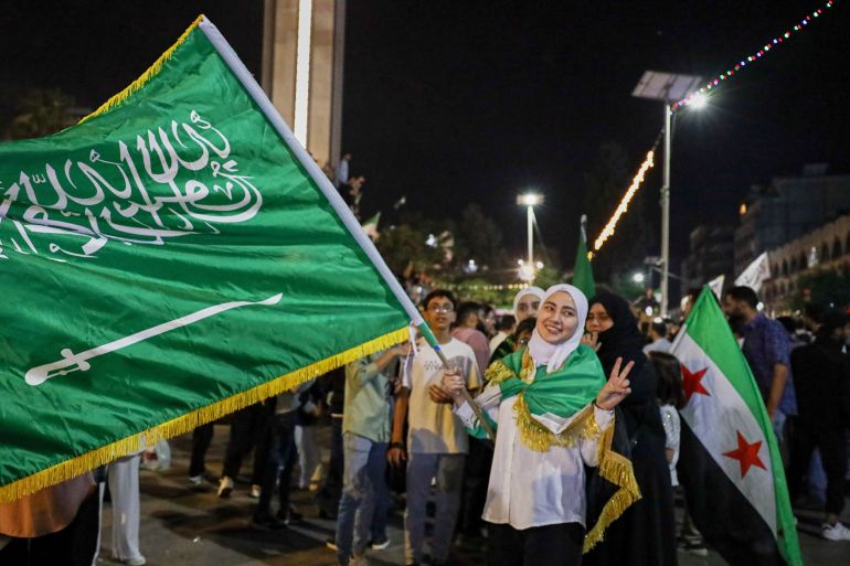 ap_6824610263a95-1747214594 A girl holds a Saudi flag in celebration after U.S. President Donald Trump announced plans during his visit to Saudi Arabia to ease sanctions on Syria and normalize relations with its new government, in Homs, Syria, late Tuesday, May 13, 2025.(AP Photo/Omar Albam)