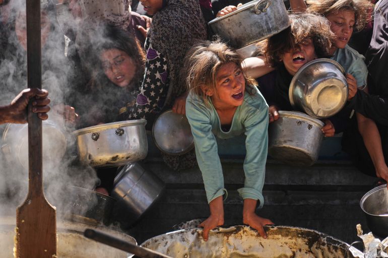 ap_68273f5276201-1747402578 Palestinians struggle to get donated food at a community kitchen in Khan Younis, Gaza Strip, Friday, May 16, 2025. (AP Photo/Abdel Kareem Hana)