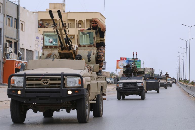 ap_683b1150c59ec-1748701520 Libyan armored vehicles patrol after clashes between heavily armed militias in Tripoli, Libya, Wednesday, May 14, 2025.(AP Photo/Yousef Murad)