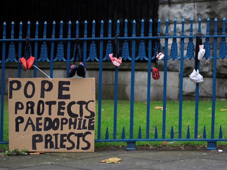 A girl ties baby shoes to a fence as a part of a protest to highlight child abuse at the hands of the Catholic church, during the visit of Pope Francis to Dublin, Ireland, August 26, 2018. REUTERS/Gonzalo Fuentes