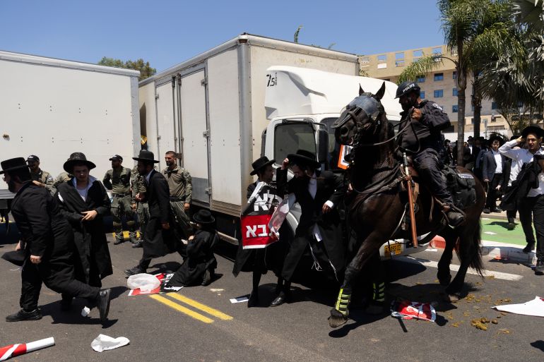 getty_6823499b3f-1747143067 RAMAT GAN, ISRAEL - AUGUST 5: Ultra-Orthodox Jewish men clash with mounted police officers during a demonstration against drafting to the Israeli military near a recruitment base on August 5, 2024 in the Tel HaShomer area of Ramat Gan, Israel. Hundreds of Ultra-Orthodox men who were previously exempted from military service were due to arrive at the recruitment office here today, following a Supreme Court ruling that ended the exemption for yeshiva students. (Photo by Amir Levy/Getty Images)